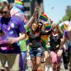 A group of people waving rainbow flags at Boston Pride parade