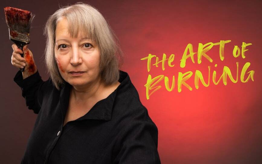 promotional poster for Kate Snodgrass's play "The Art of Burning," featuring the play title painted on a red background. A woman holding a paint brush with some paint smudges on her face stares at the camera intensely next to the title