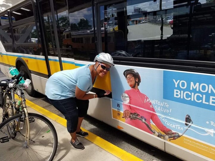 Vivian Ortiz, 60, poses with a photo of herself on the side of an MBTA bus, part of a city campaign to promote biking in 2019