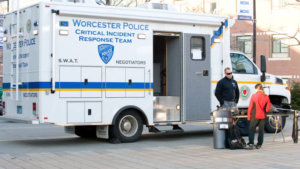 Two people stand outside a Worcester Police Critical Incident Response Team van