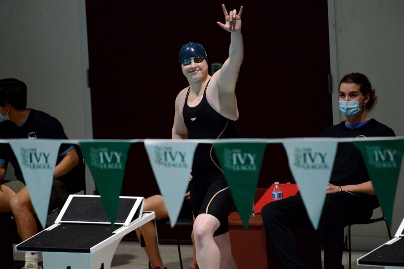 A swimmer raises their arm towards the crowd.