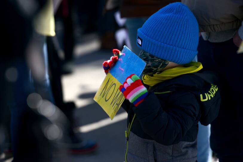 A small child holds up a sign.