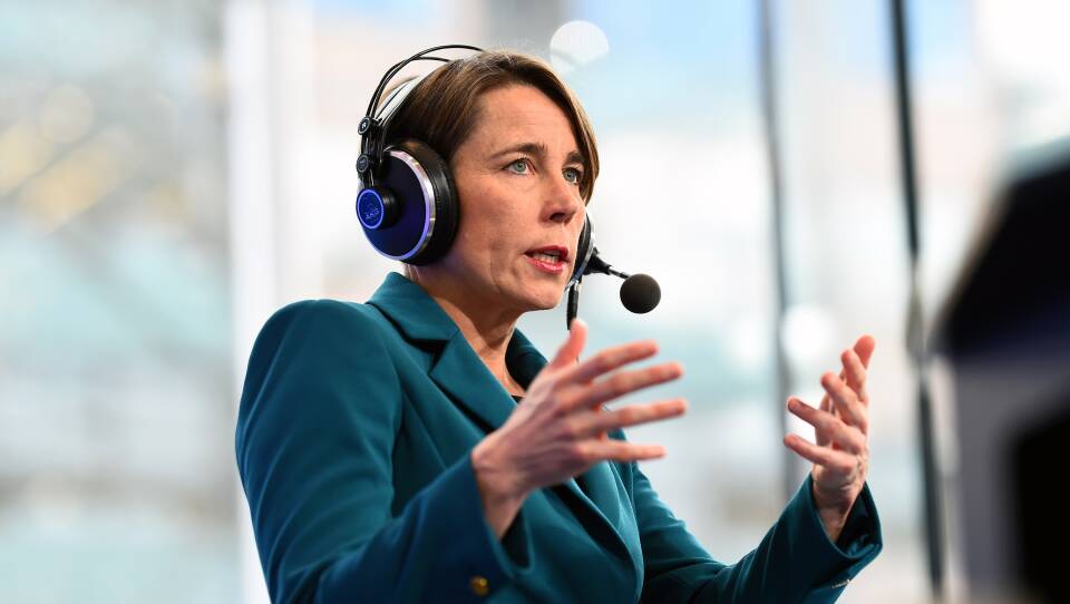A woman in a blazer speaks into a radio headset
