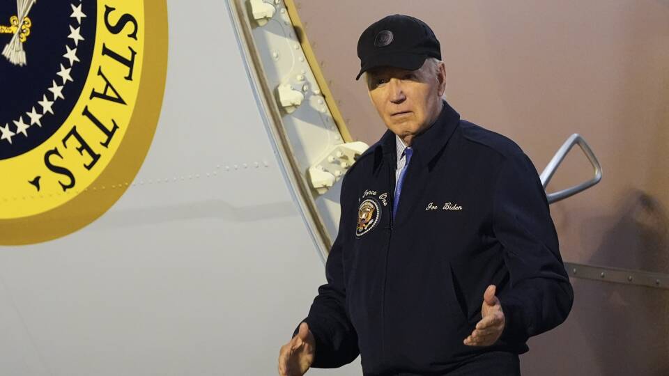 A man in a fleece zip-up and baseball cap disembarks from a plane.
