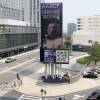 A city street with a large electronic billboard advertising the NAACP National Convention, July 26-Aug. 1.