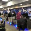 Staff at a Southwest Airlines ticket counter speak with travelers.
