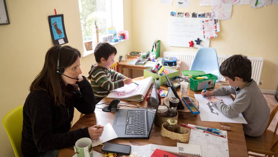 Six-year-old Leo (R) and his three-year old brother Espen (C) complete homeschooling activities suggested by the online learning website of their infant school, as his mother Moira, an employee of a regional council, works from home in the village of Marsden, near Huddersfield, northern England.