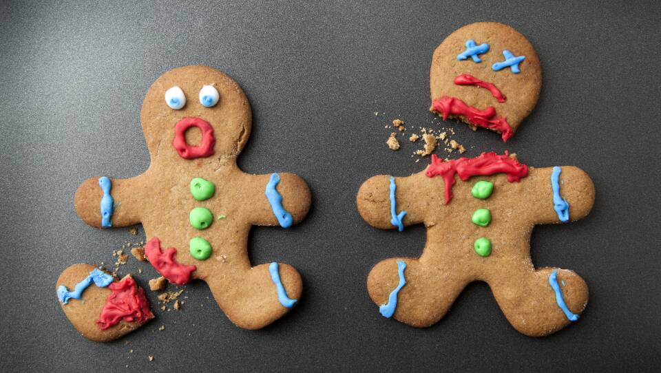 Two dismembered gingerbread people, one with a broken-off leg and the other with a broken-off head, with icing to indicate shocked or dead faces.