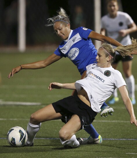 Two soccer players look in conflict as they fight for the ball