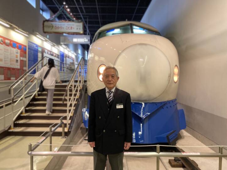 A man stands in front of a train in a museum