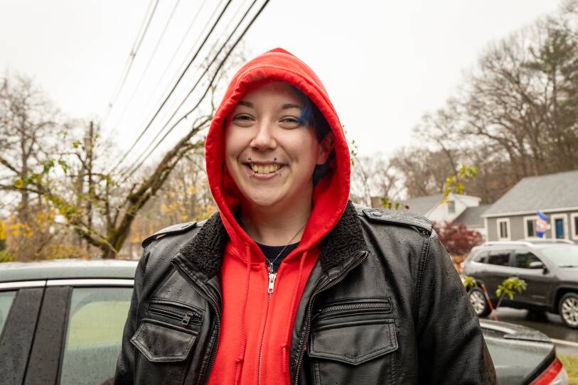 Portrait of Beverly paraprofessional Emlyn Marcinkowski, in a hood in the rain near striking teachers