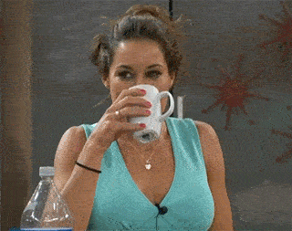 A woman laughs so hard she spits out her drink.