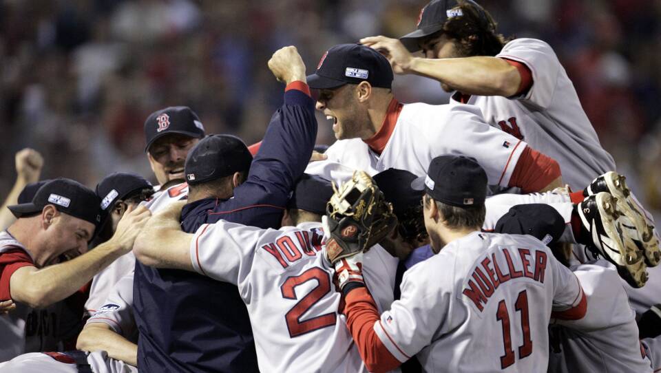Players celebrate in their uniforms and caps, jumping together with broad grins