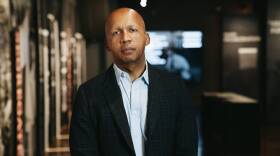 Civil rights lawyer, author, and activist Bryan Stevenson. He is wearing a blue button-down shirt and a black checkered blazer.