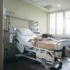 Empty hospital bed near sunny window