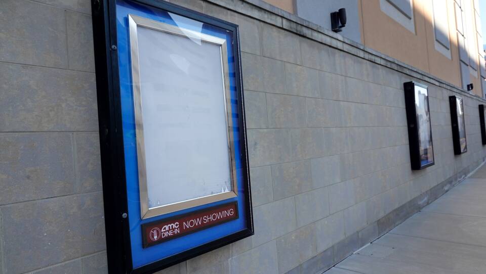 Empty frames that would normally hold movie posters hang on the front of an AMC theater shuttered by the coronavirus pandemic on Dec. 4, 2020, in Rosemont, Ill.