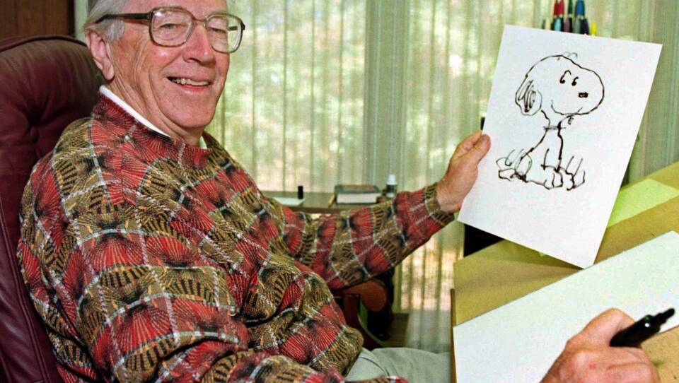 Cartoonist Charles Schulz poses with a sketch of Snoopy in his office in Santa Rosa, Calif. Schulz, who died shortly after his retirement in 2000, would have turned 100 on Nov. 26.