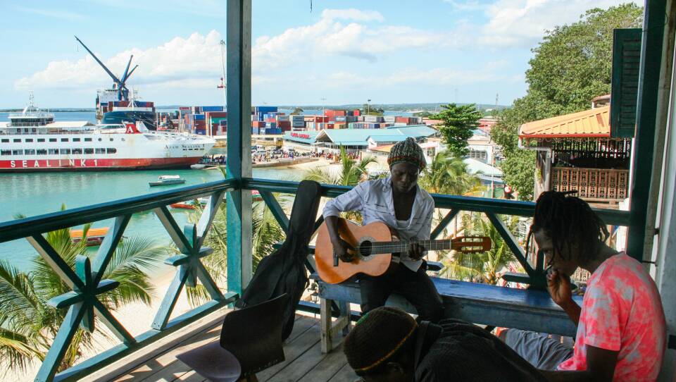 Students at the Dhow Countries Music Academy, dedicated to preserving the music known as "taarab," play on a balcony overlooking Zanzibar's port.