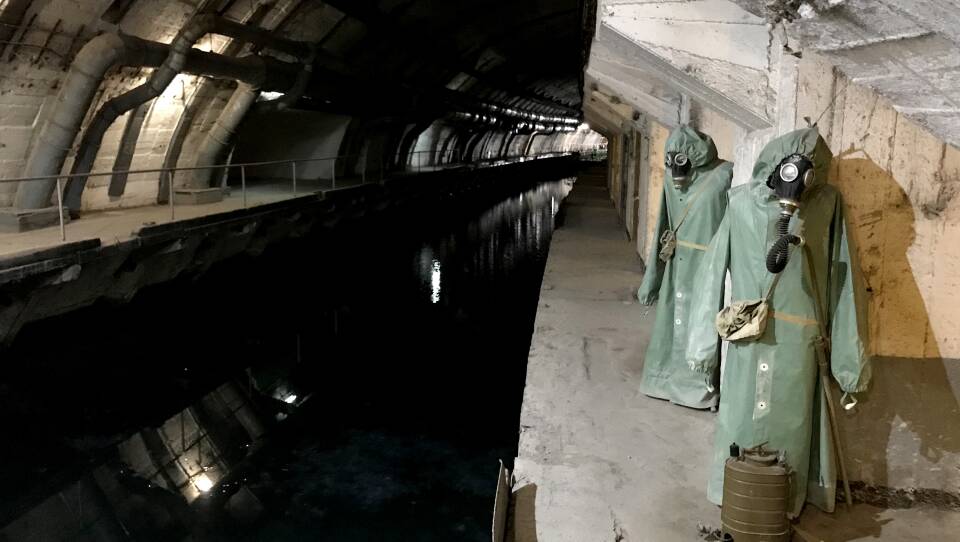Hazmat suits hang next to the canal that leads from Balaklava Bay to the heart of the underground base.