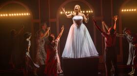 Eva Peron stands on a box in front of a small crowd in American Repertory Theater's production of "Evita"