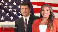 A man and a woman in front of the American Flag