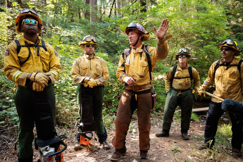 Cal Fire Captain Eric Ayers briefs members of the California National Guard's Task Force Rattlesnake before they spend the day clearing brush and small trees, all part of fire prevention tactics.