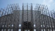Metal scaffolding covers the front of a white facade of a stadium.