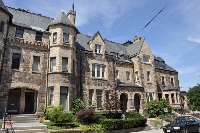 This is a photograph of residences in Brookline, Massachusetts. They were built in 1889 out of yellow brick and stone. They resemble a Chateau, with steeply pitched roofs and decorative gabled wall dormers.