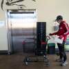 A grocery store worker sanitizes a shopping cart at a MOM's Organic Market in Washington, D.C. in April 2020.