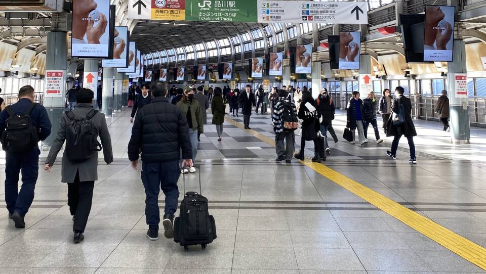 Passengers walk through a train station.