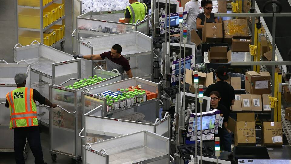 Workers pack orders at an Amazon fulfillment center on January 20, 2015 in Tracy, California. OSHA cited Amazon after federal safety inspectors found ergonomic hazards at three Amazon warehouses.