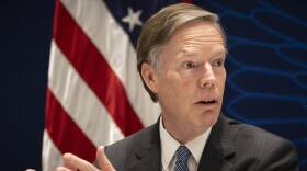 Nicholas Burns wears a suit and gestures while speaking.