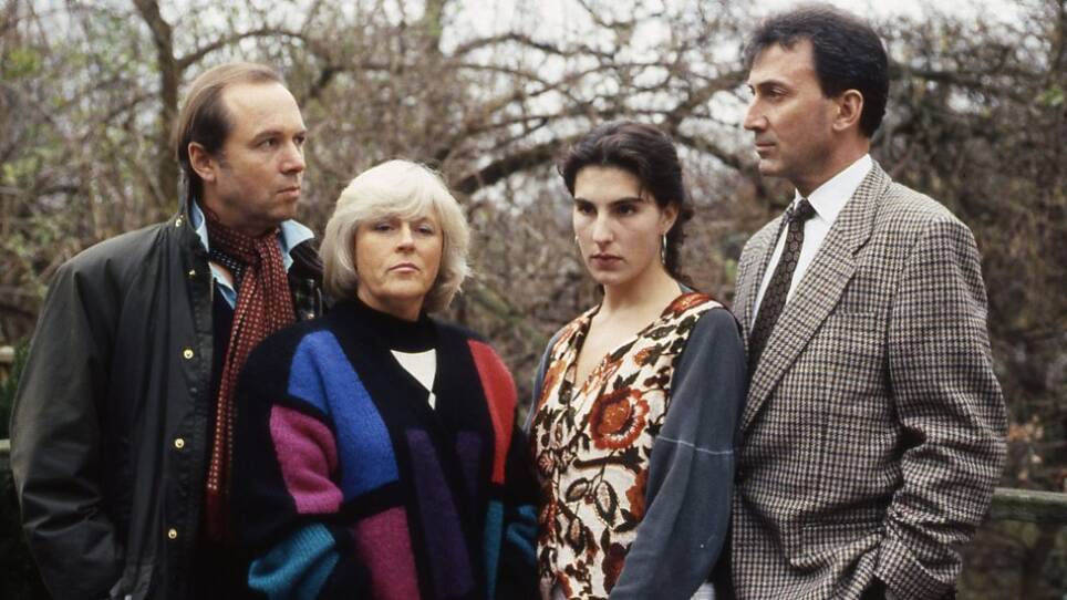 Two Couples, stand in an orchard. The women look off into the distance as the men glare at each other.