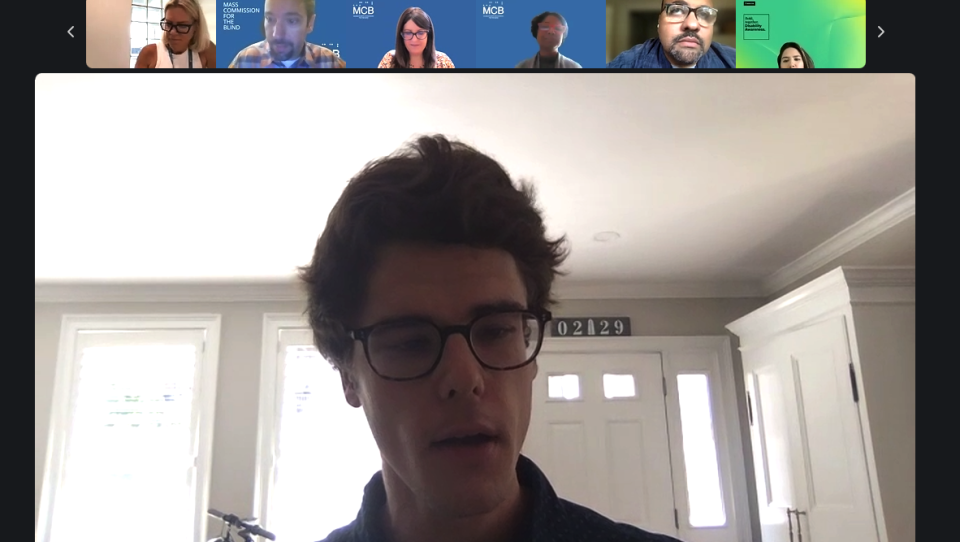 A screenshot of a Zoom call shows a young man with glasses in a large window speaking. Above him are a row of people, some with blue MCB backgrounds.