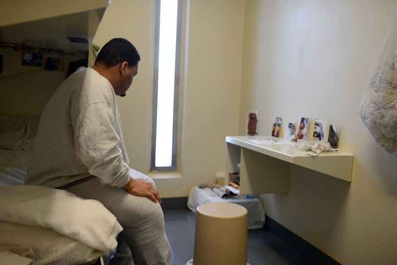 Eric Darden in his 80-square-foot cell. Pictures of his girlfriend and young daughter line the desk.