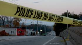 Police tape crosses a Maine road at dusk