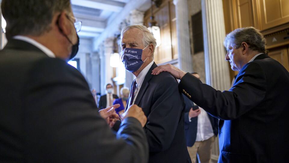Sen. Angus King, I-Maine, center, speaks with Sen. Gary Peters, D-Mich., left, while Sen. John Kennedy, R-La., walks by at right, as the Senate voted to formally begin debate on a roughly $1 trillion infrastructure plan on Friday.