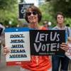 A woman holds signs at a rally at the state Capitol on June 20 in Austin, Texas, to fight SB7, a controversial voting bill.