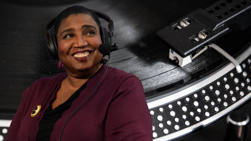 A woman in a radio headset is overlaid over a turntable image.