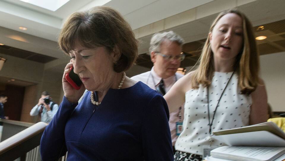 Sen. Susan Collins, R-Maine, talks on a phone while walking to a room on Capitol Hill to read the report on the supplemental FBI investigation into Supreme Court nominee Judge Brett Kavanaugh.