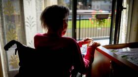 Disabled senior woman in wheelchair at home in living room