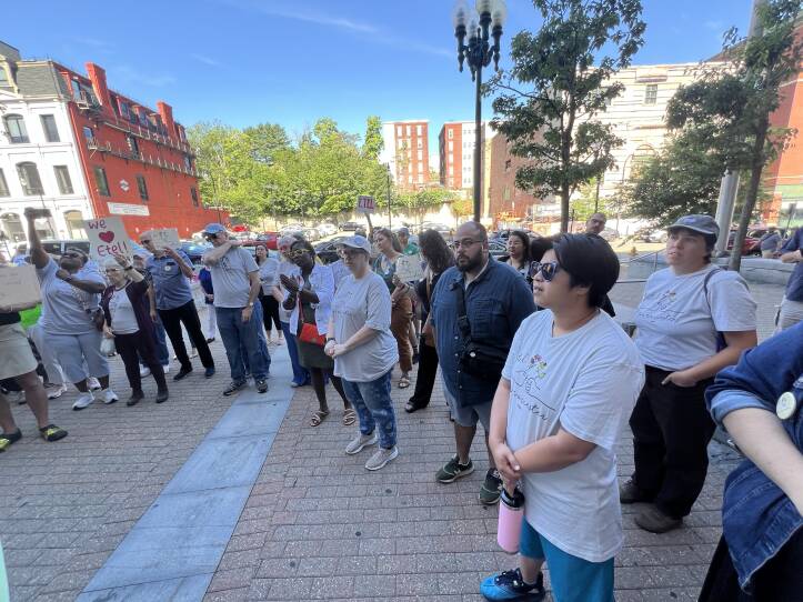 A crowd of people listens to a Worcester city councilor speak.