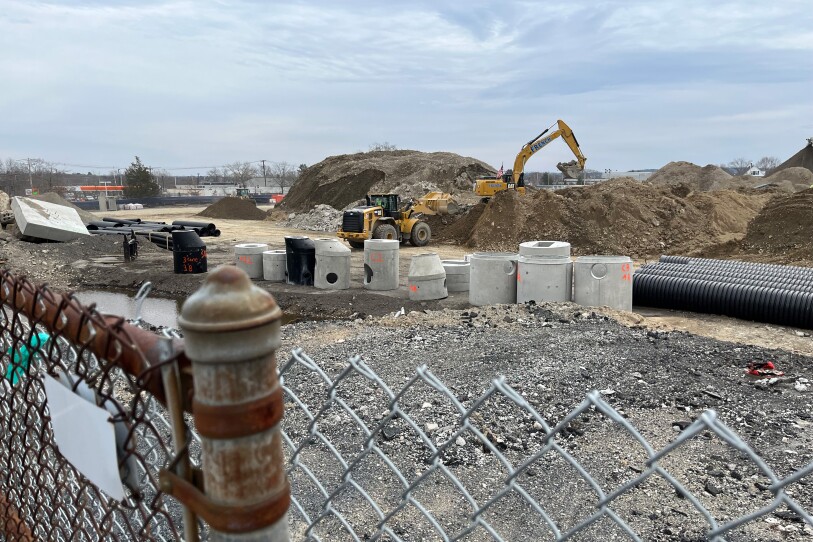 A construction site behind a chain link fence.