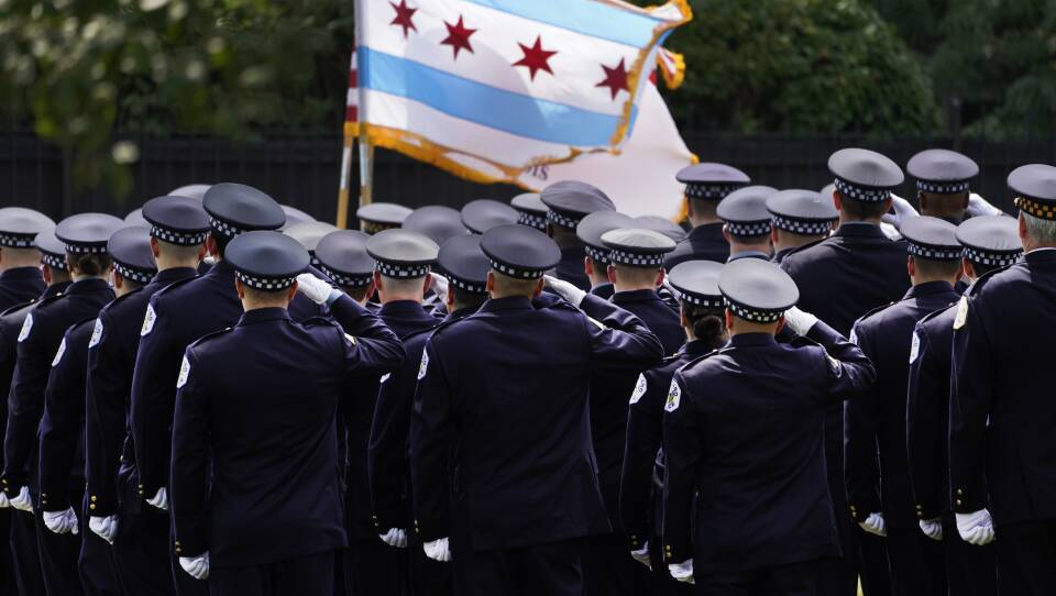Chicago police officers salute the state flag on Aug. 18.