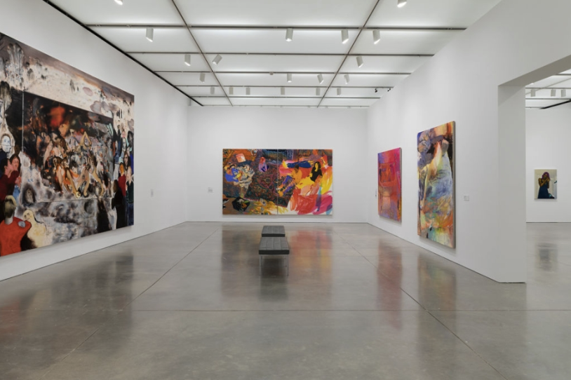 Massive unframed canvases displayed in an empty exhibit hall with white walls