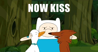 A person pushes together two friend's faces and says "NOW KISS."