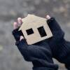 young homeless boy holding a cardboard house