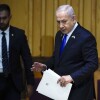 Natanyahu wears a suit and tie, carrying pre-written remarks.