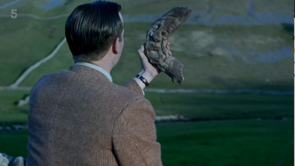 James holds up a Cailleach, a hand carved wooden face