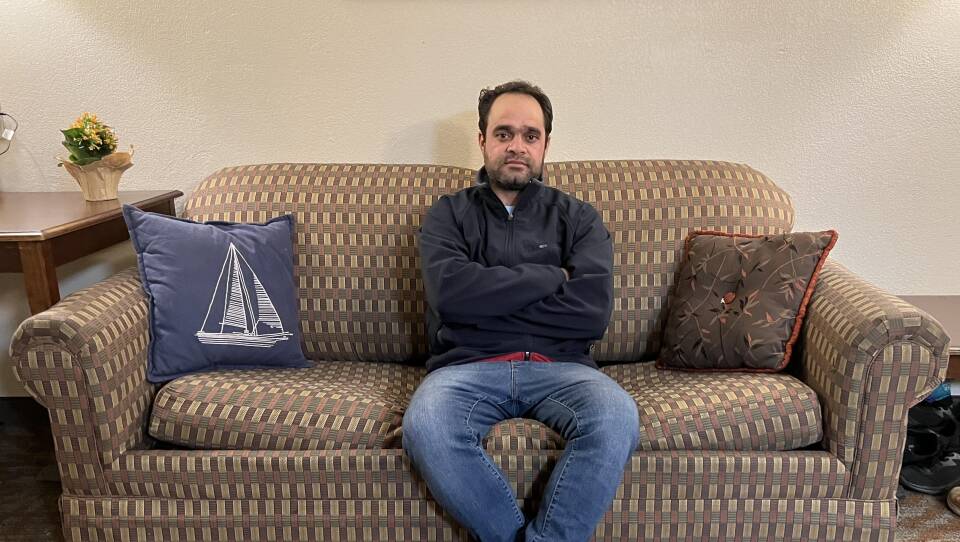 A man sits on a couch.